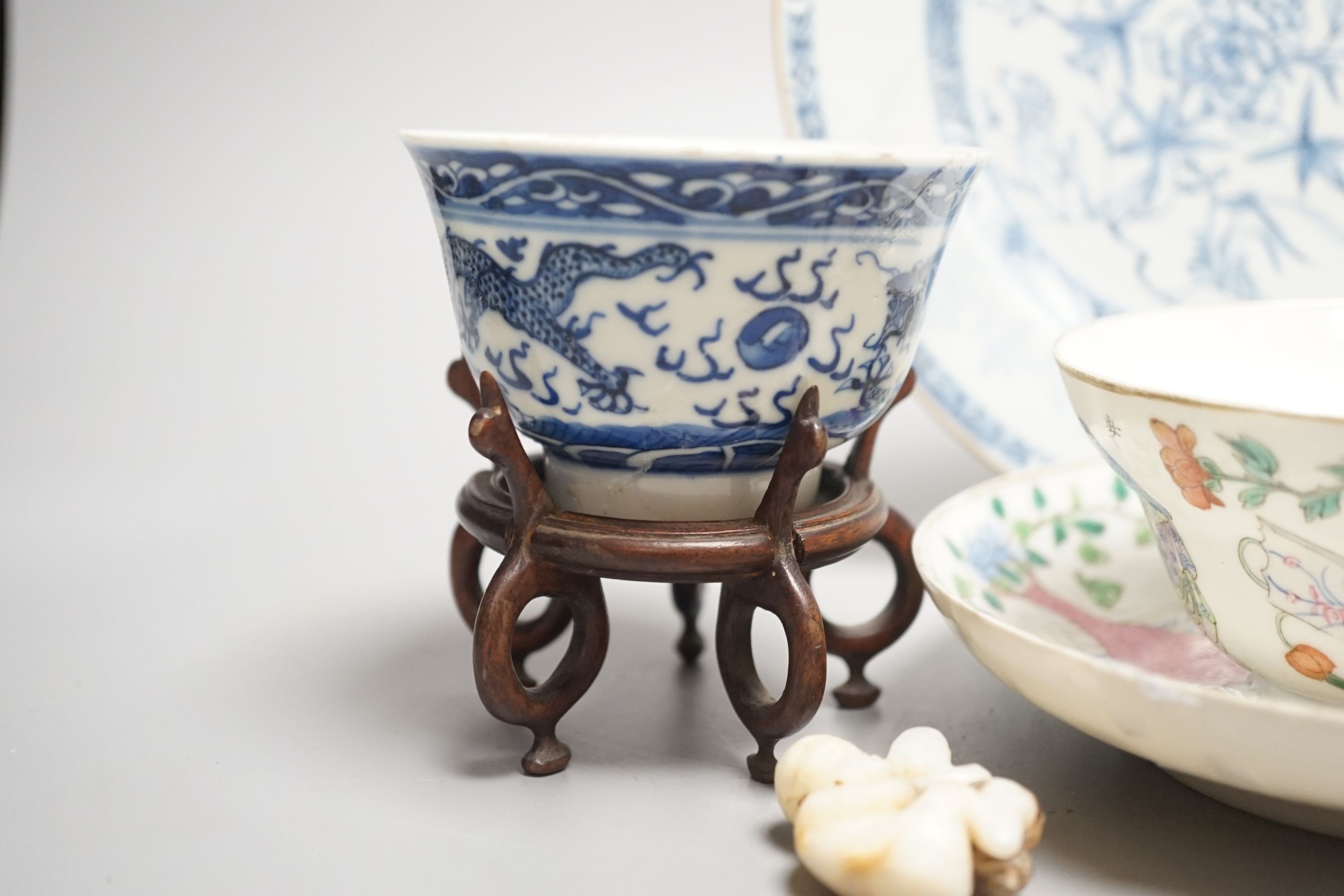 A 19th century Chinese famille rose bowl and saucer, a blue and white tea bowl on stand, a hardstone carving and three 18th century blue and white plates